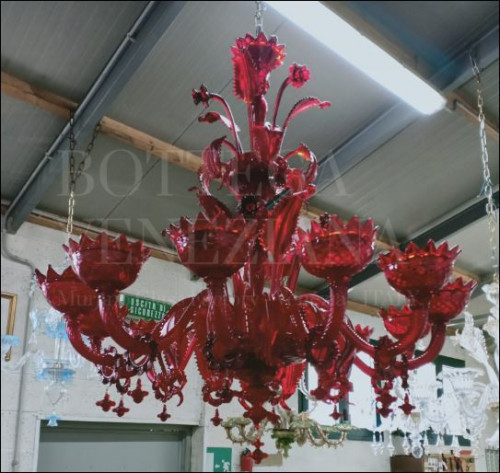 Lampadario modello WEZEN con palchetto in rosso rubino veneziano realizzato per "Le Potazzine", azienda produttrice di vino rosso di Montalcino. Il colore rosso è realizzato "in fuoco" nella fornace di Bottega Veneziana conferendo effetti di luce spettacolari, che rimandano ai meravigliosi riflessi del famoso vino toscano.