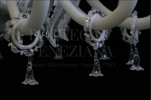 Particolare di lampadario modello ALGIEBA in vetro soffiato di Murano colore bianco e cristallo. Prodotto artigianale realizzato completamente a mano con la tecnica dell'INCAMICIATURA: il colore bianco viene ricoperto con uno strato di vetro cristallo, conferendo così dei riflessi di luce spettacolari.