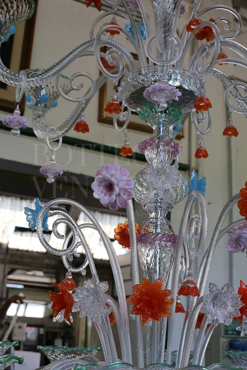 Lampadario classico in vetro di Murano modello PAVAROTTI in cristallo decorato con fiori multicolore. Realizzato interamente a mano nella fornace di Bottega Veneziana secondo le tradizionali tecniche di lavorazione del vetro veneziano. Prodotto artigianale made in Italy 